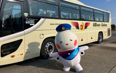 バスの前で両手を広げてポーズを取るそらやん