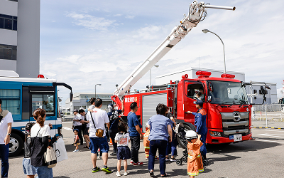 空港の消防車を見学する親子連れの写真