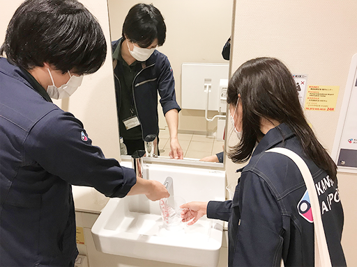Staff members checking the rate of water running out of a faucet.