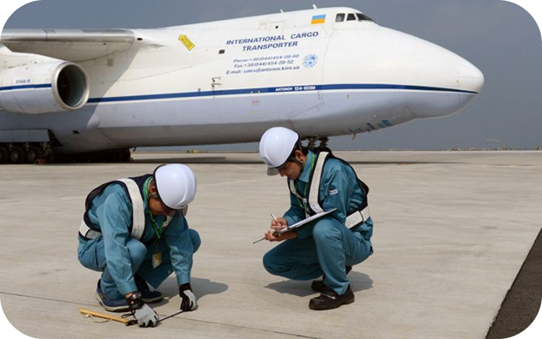 Two staff members inspecting an aircraft parking apron.